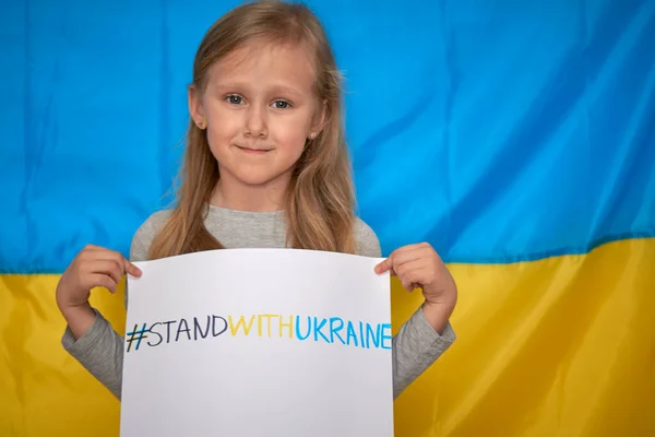 Mãos de menina segurando banner com amarelo-azul desenhado staywithUkraine hashtag. Parar conceito de guerra Imagens De Bancos De Imagens Sem Royalties