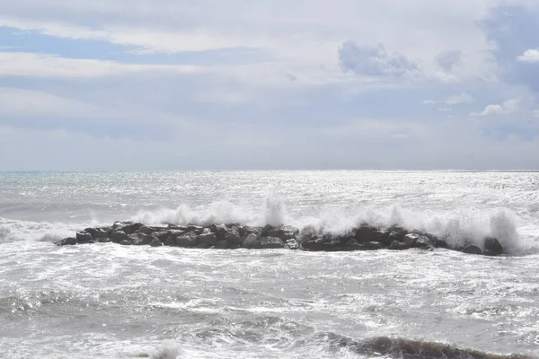 Okyanusun kıyısında dalgalı bir deniz, fırtınalı bir gökyüzü.