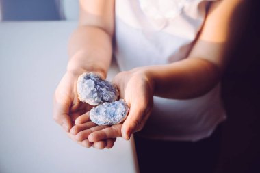 Young 7 year old girl child holding clusters of blue crystals called Celestite. An Indigo Child concept, New Age Term. clipart