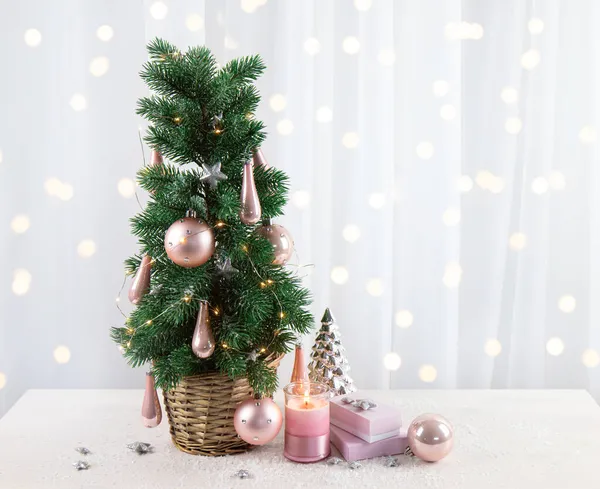 現代のパステルピンクの色の泡の装飾ピンクの贈り物やキャンドル燃焼と 自宅のリビングルームでクリスマスツリーにかかっています パステルピンクのスタイルのクリスマスのコンセプト 白の上のコピースペースの多く — ストック写真