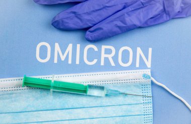 Yeni Coronavirus Covid-19 mutasyon Omicron konsepti. Tıbbi maske, şırınga ve Omicron harfli metin..