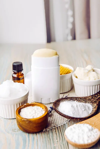 Making homemade deodorant stick with all natural ingredients concept. Wooden background. Ingredients: arrowroot powder, baking soda, beeswax, shea butter, essential oil, cornstarch, coconut oil.