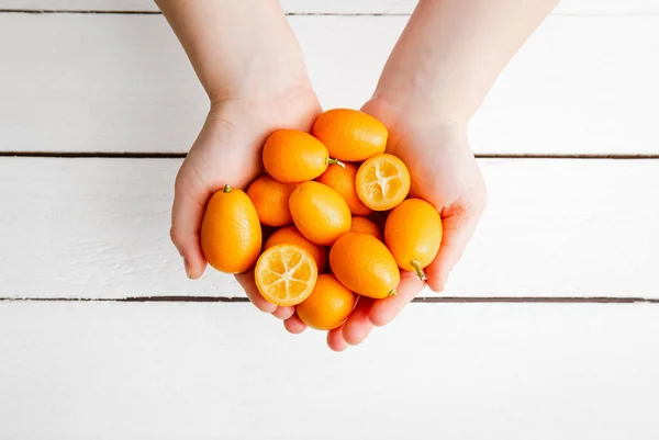 Vista Superior Manos Niños Sosteniendo Kumquats Cumquats Citrus Japonica Sobre — Foto de Stock