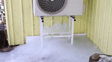Evdeki sarı duvardaki askının üzerinde klima makinesi var. Soğuk kış günlerinde altında çok buz olur..