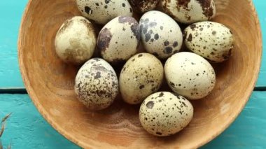 Doğal renkte ahşap kasede bıldırcın yumurtaları ahşap tahta tahta arka planda. Sağlıklı gıda konsepti.