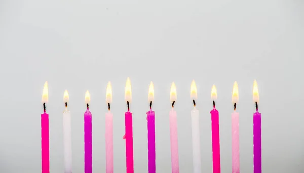 Verschiedene Rosafarbene Geburtstagskuchenkerzen Die Einer Reihe Auf Grauem Hintergrund Brennen — Stockfoto