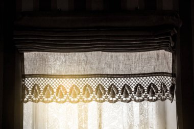 Güneşli bir günde, iç mekanda, ev penceresinde Roma gözlüğü adı verilen keten perdeler..