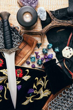 Fantezi rol yapma oyunu hala hayat konsepti. Çeşitli karakter nesneleri araçlarıyla dekore edilmiş arka plan. Hançer, zincir maili, tılsım, giysi, zar seti: D10, D20, D12, D6, D8.