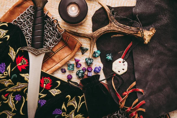 Fantezi rol yapma oyunu hala hayat konsepti. Çeşitli karakter nesneleri araçlarıyla dekore edilmiş arka plan. Hançer, zincir maili, tılsım, giysi, zar seti: D10, D20, D12, D6, D8.