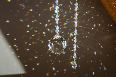 Evde asılı duran top ve gözyaşı damlası kristal gökkuşağı yapıcı güneş yakalayıcıya odaklan. İyi Feng Shui, Sha Chi enerji akışı konsepti. Odada güzel bir bahar ışığı.