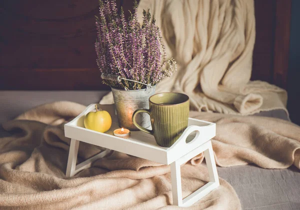 可爱的木制早餐托盘 腿在家里的床上 一杯热茶 茶点蜡烛和石南花 秋装搭配围巾和针织毛衣 斯堪的纳维亚土拨鼠生活方式 — 图库照片