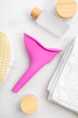 Kadınlar için alet, çiş hunisi, ayakta işemeye yardım eden alet. Hijyen ürünleri arasında pembe silikon huni. Düz manzara, stüdyo çekimi..