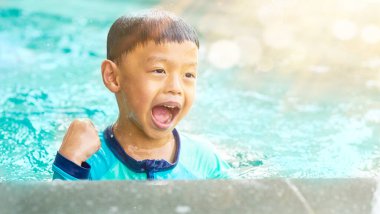 Çocuk yüzme havuzunda oynuyor yazın neşe ve neşe içinde gülümseyip eğleniyor.