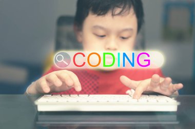 Çocuk bilgisayar teknolojisi kullanarak ödev arıyor. İnternetten öğreniyor.