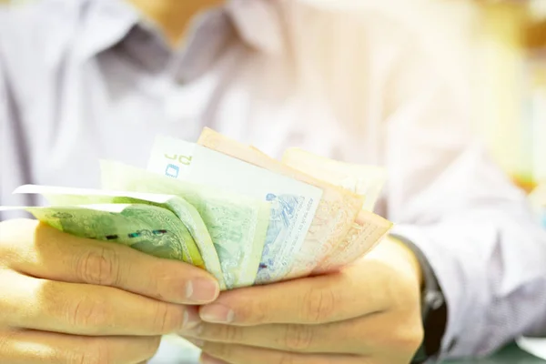 Üniformalı adam ekonomik kriz konsepti için para banknotu sayıyor