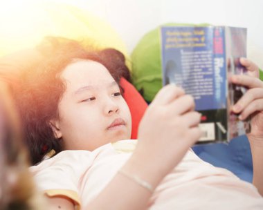 Çocuk yalan söylüyor ve kitap okuyor.