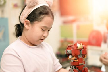 Çocuklar odada plastik blok oyuncağı oynuyorlar.