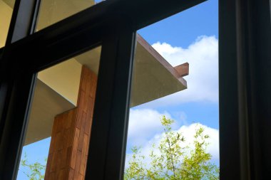 Binanın saçakları, binanın içinden düşük açılı bir açıyla bakıyor, arka planda gökyüzünü görüyor.