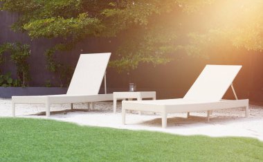 Yeşil çimenli ve ağaçlı plaj sandalyeleri