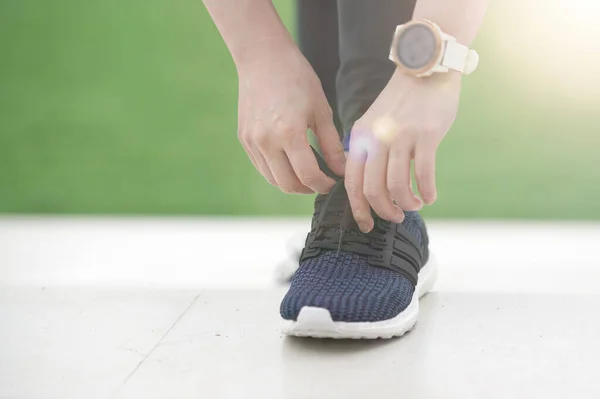 woman runner tying running shoes