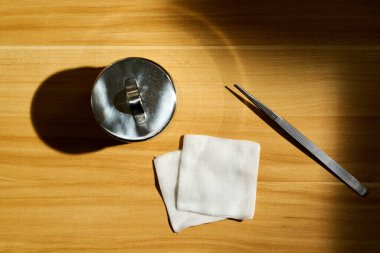 Gazlı bez ve konteynır masanın üstünde.