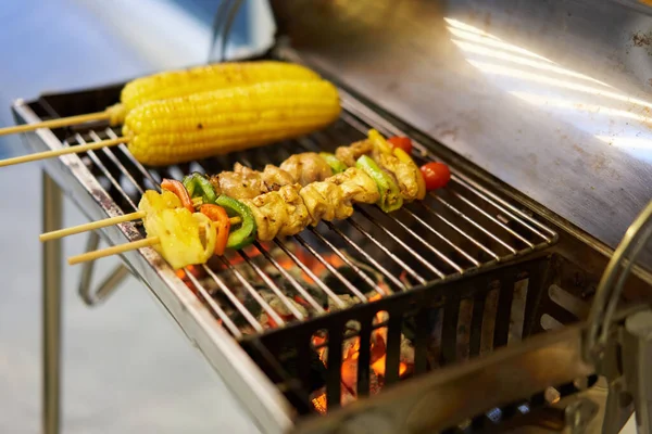 Bahçe partisi barbekü ızgarası. Kavrulmuş mısır çubuğu, barbekü ocağında yemek pişirme, yakın çekim..