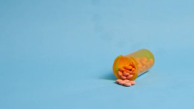 Mavi arka planda haplar ve güvenlik kapağı şişesi