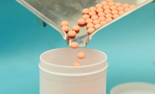 pharmacist pour pills into bottle