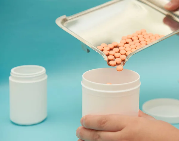 pharmacist pour pills into bottle