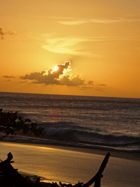 Bulutun arkasına gizlenmiş, güneş denizin üzerinde batıyor.