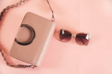 Pembe masada güneş gözlüklü kadın çantası.