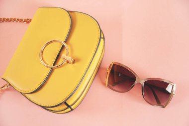Pembe masada güneş gözlüklü kadın çantası.