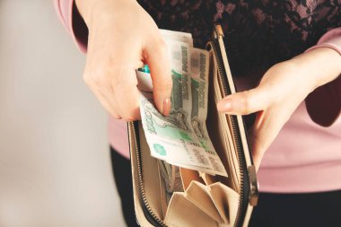 Kadın çantayla para veriyor.