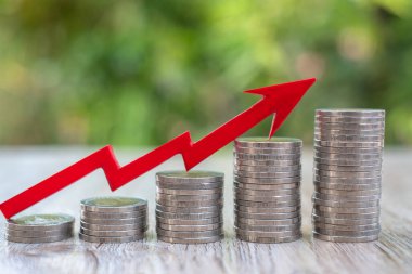 Aşağıdan yukarıya sıralanmış bozuk paraların üzerindeki kırmızı oklar. İş büyümesi konsepti Emlak Finansal Planlama Hesap Yönetimi ve bir başarı grafiği.