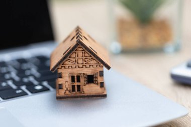 Ev dizüstü bilgisayarda. Emlakçı, anahtarları müşteriye teslim ediyor. İpotek konseptleri. Konutlar için kira, satın alma ve sigorta.