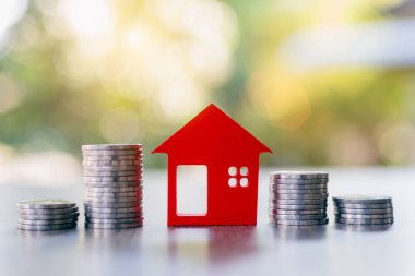 Kırmızı evler ve bir yığın bozuk para. Ev bazlı kredi fikirleri. Finans paralarından gelen para. Başarılı finansal işler. Emlak projeleri, ipotekler, kiralar için tasarruf.
