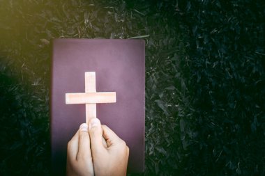 Elinde bir haç ve bir kutsal kitap var. Dua düşünceleri, Hıristiyanlığın ıstırabından kurtulmak için dua eder. İnan bana. Tanrı 'nın ilahi gücüne dua et..