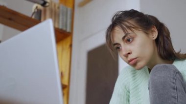 Kadın rahat bir ofiste dizüstü bilgisayarla çalışıyor. Dairendeki kanepede oturan serbest çalışan kadın.