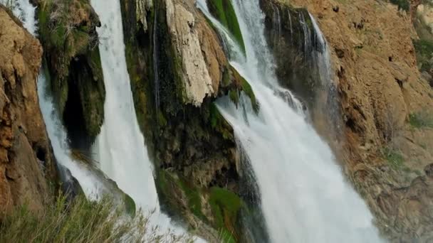 Riprese al rallentatore di Low Duden Waterfall ad Antalya, Turchia. un flusso grandioso e potente di acqua sfocia in un mare turchese tempestoso con onde che si infrangono contro le rocce costiere — Video Stock