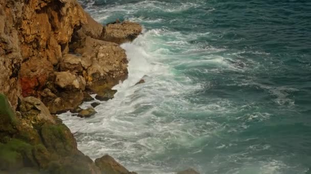 Witalność niebieskiej energii i czystej wody oceanu. Potężne burzliwe fale morskie Rozbijając się na klifach wybrzeża Morza Śródziemnego z piankową białą fakturą. Antalya, Turcja — Wideo stockowe