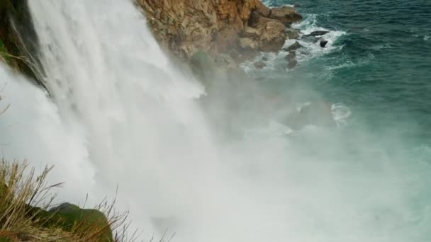 Riprese al rallentatore di Low Duden Waterfall ad Antalya, Turchia. un flusso grandioso e potente di acqua sfocia in un mare turchese tempestoso con onde che si infrangono contro le rocce costiere — Video Stock