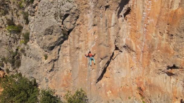 Légi felvétel a drónról. Drón repül ki a mészkő szikláról sziklamászóval rajta. ember mászik kihívást jelentő útvonal függőleges szikla — Stock videók