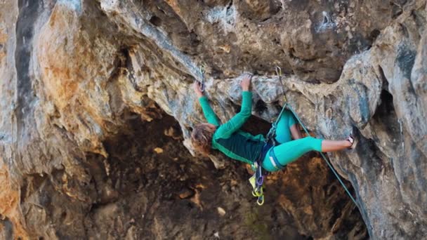 Silná žena rock horolezec leze tvrdý tuhý rock cesta na velmi převislé černé útesy v jeskyni. — Stock video