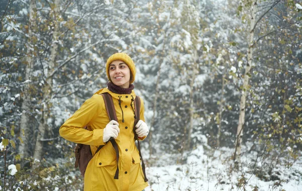 En kvinne som går alene i vinterskogen og nyter villmarken. Vinteren kommer – stockfoto