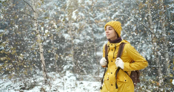 Kvinne på fottur i den kalde skogen dekket av snø. Vinteren kommer, første snøfall. – stockfoto