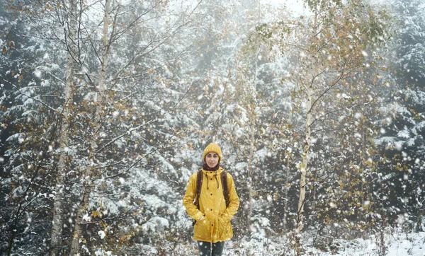 Portrettkvinne i gul slitasje stående i snødekt vinterlandskap – stockfoto