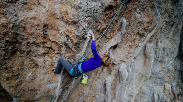 Starkes Klettermädchen erklettert Tuffstein auf überhängendem Felsen. — Stockvideo