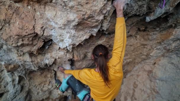 Lucht filmische slow motion van sterke bekwame man rock klimmer klimt op overhangende rots klif. mens maakt moeilijke en moeilijke inspanningen en bewegingen. — Stockvideo