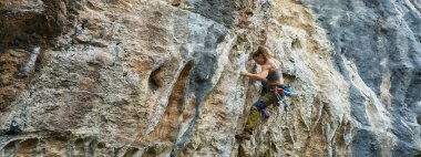 Panoramik görüntü güçlü kadın güzel kaya duvarına tırmanıyor, taş kayalık dokusu