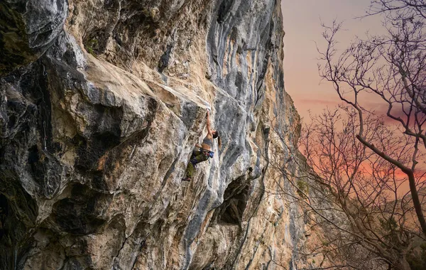 Schönes Bild von Felswand mit Sonnenuntergang Himmel, Bergsteiger Mädchen arbeitet auf harter Route — Stockfoto